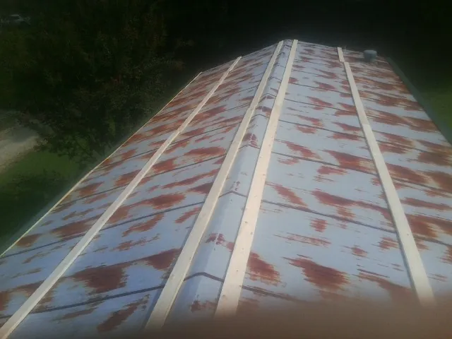 Rusted metal roof panels with new wood purlins before replacement — Storm Damage Roof Repair in Arch Cape by Roofing Brothers